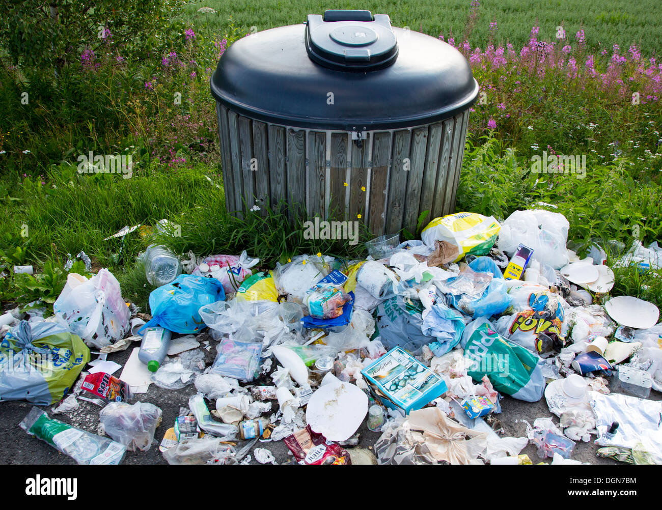 Full garbage bin and trashes dumped around it , Finland Stock Photo