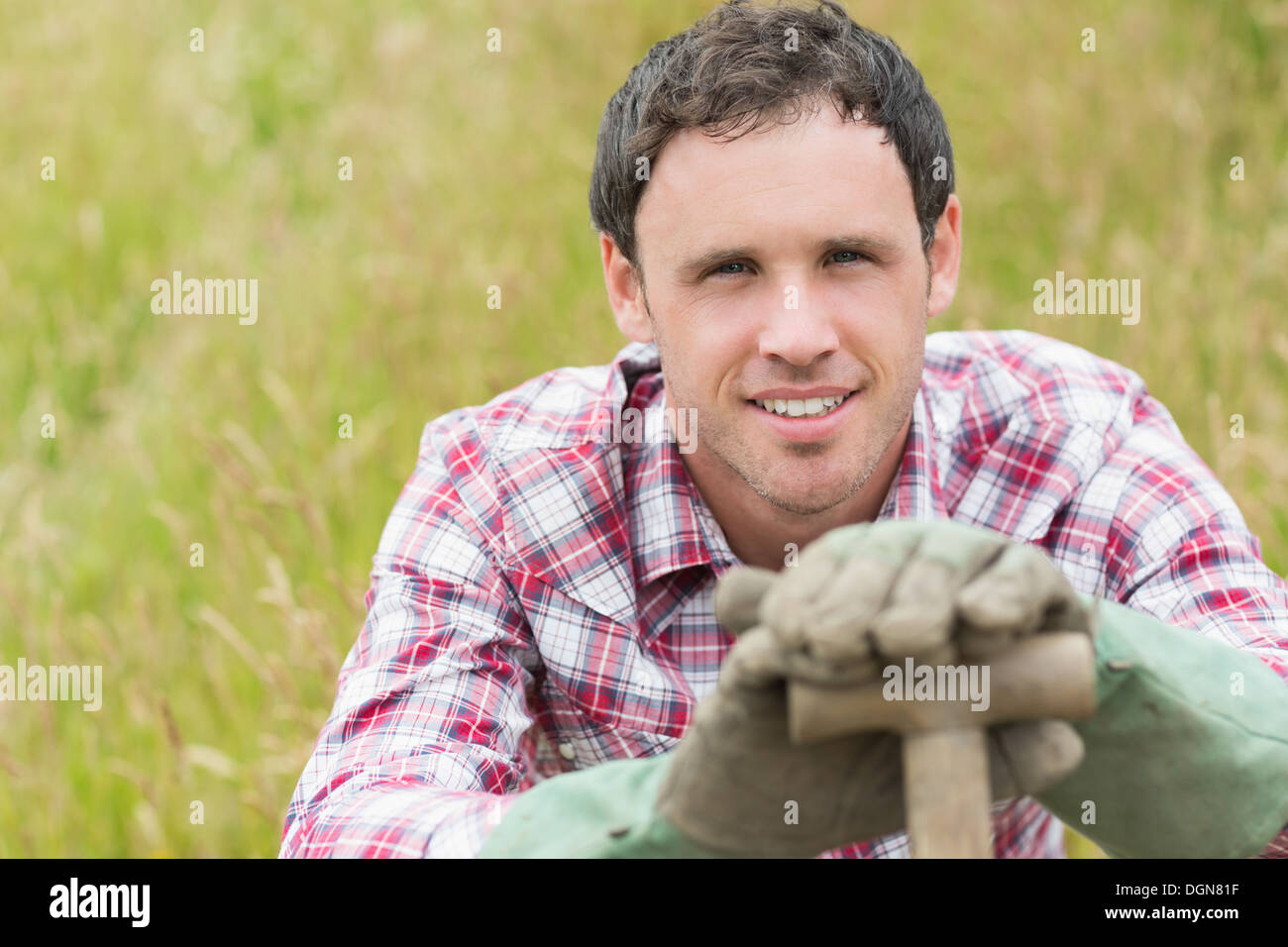 Handsome young man leaning on his shovel Stock Photo