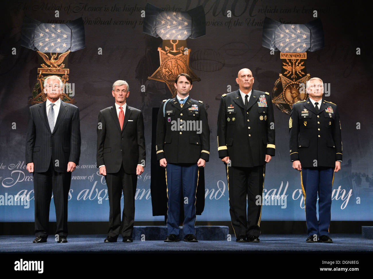 From left to right, Secretary of Defense Chuck Hagel, Secretary of the Army John McHugh, Former U.S. Army Capt. William D. Swenson, Chief of Staff of the Army Gen. Raymond T. Odierno, Sgt. Maj. of the Army Raymond F. Chandler III standing on stage at his Stock Photo