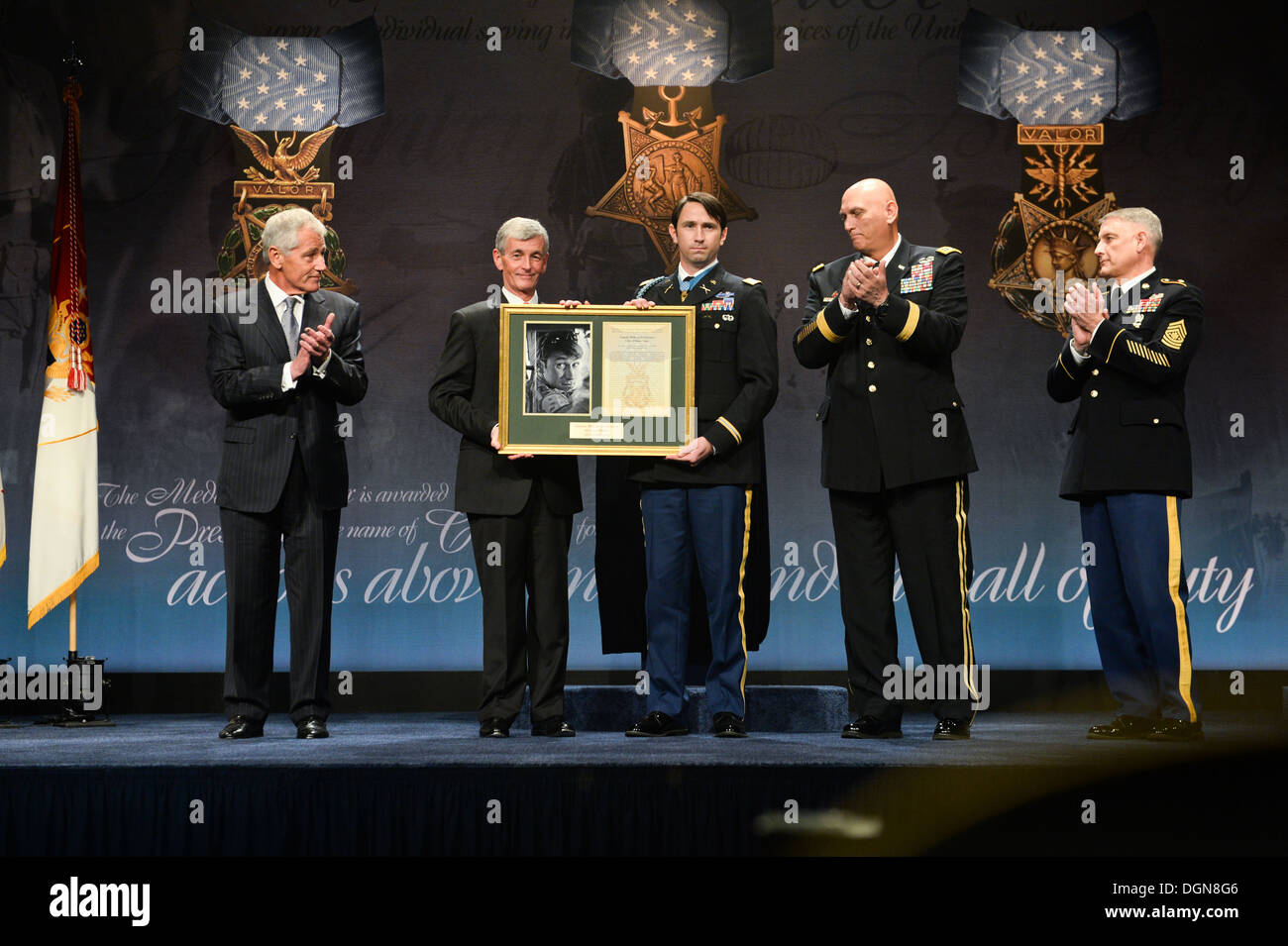 From left to right, Secretary of Defense Chuck Hagel, Secretary of the Army John McHugh, Former U.S. Army Capt. William D. Swenson, Chief of Staff of the Army Gen. Raymond T. Odierno, Sgt. Maj. of the Army Raymond F. Chandler III display a photo and citat Stock Photo