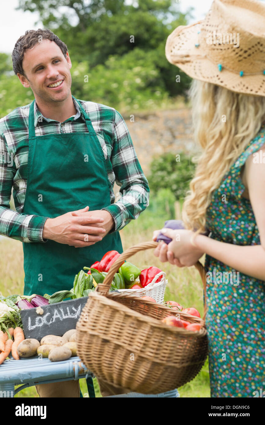 Young farmer selling organic vegetables to pretty blonde Stock Photo ...