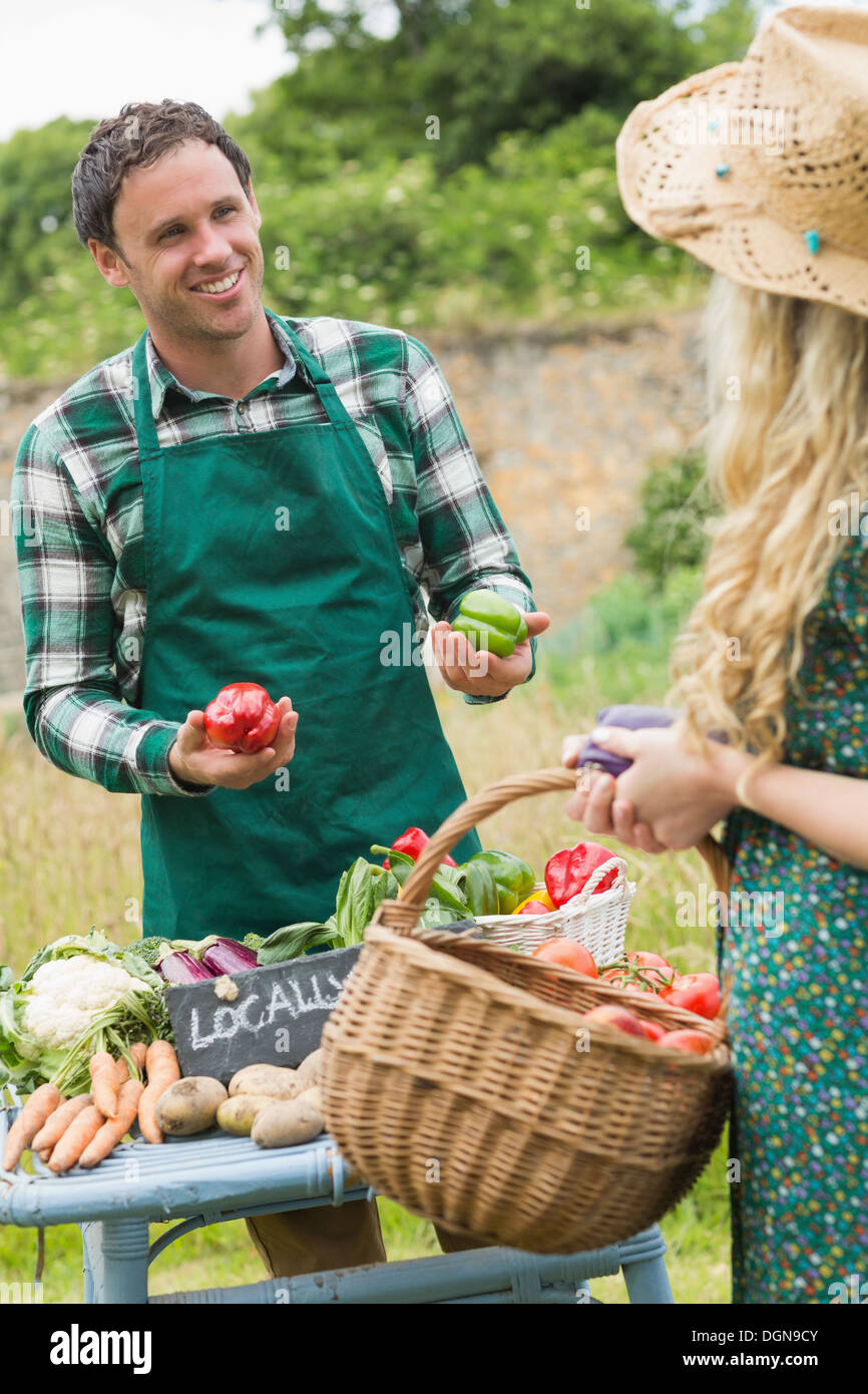 Young handsome farmer selling organic vegetables to pretty blonde Stock ...