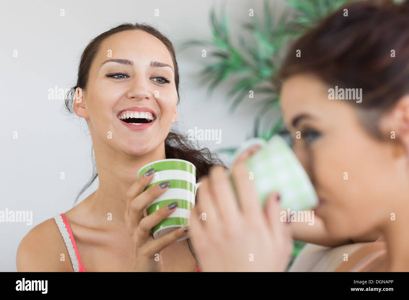 Young laughing woman having coffee with friend Stock Photo