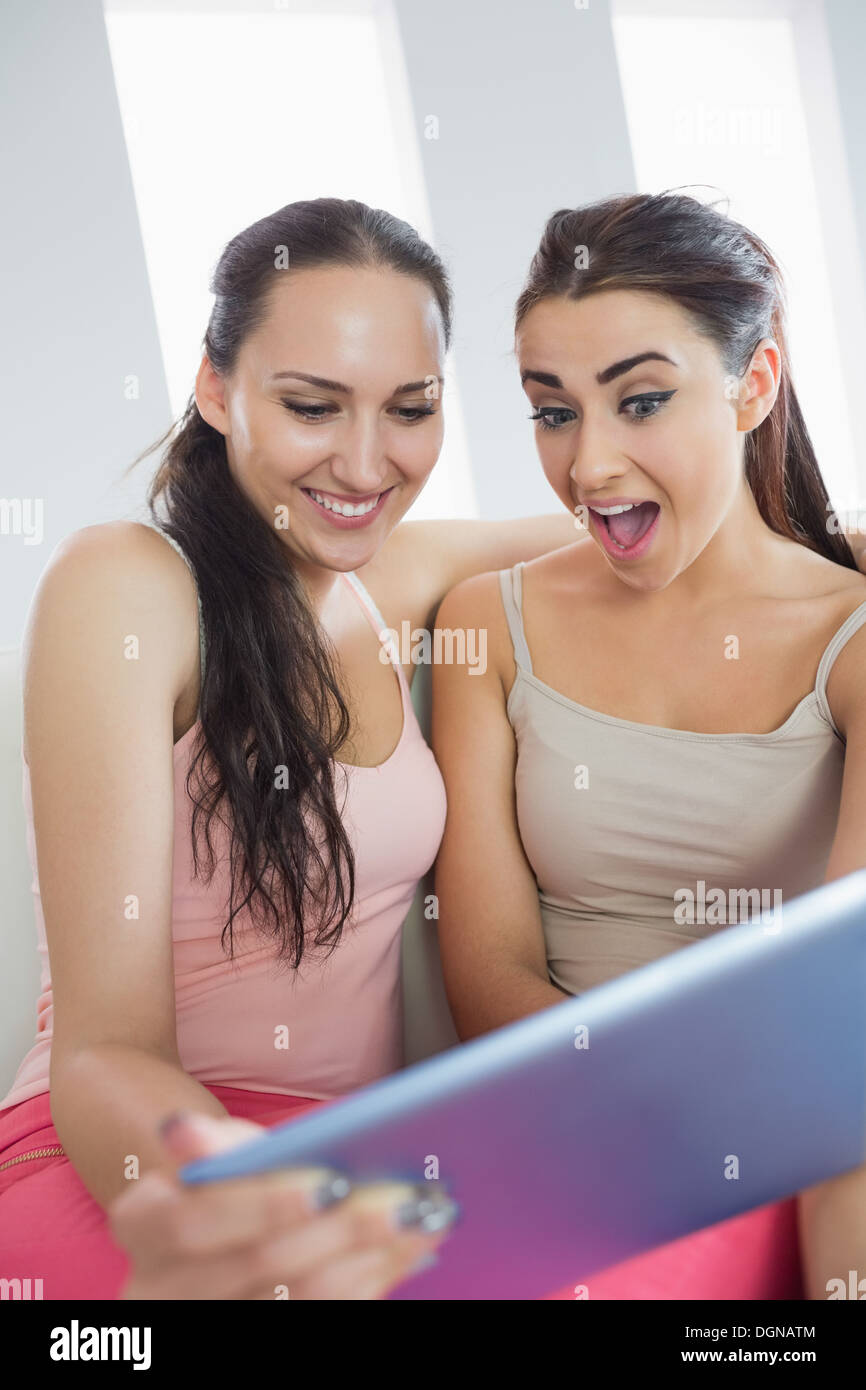 Two pretty excited women using tablet pc Stock Photo