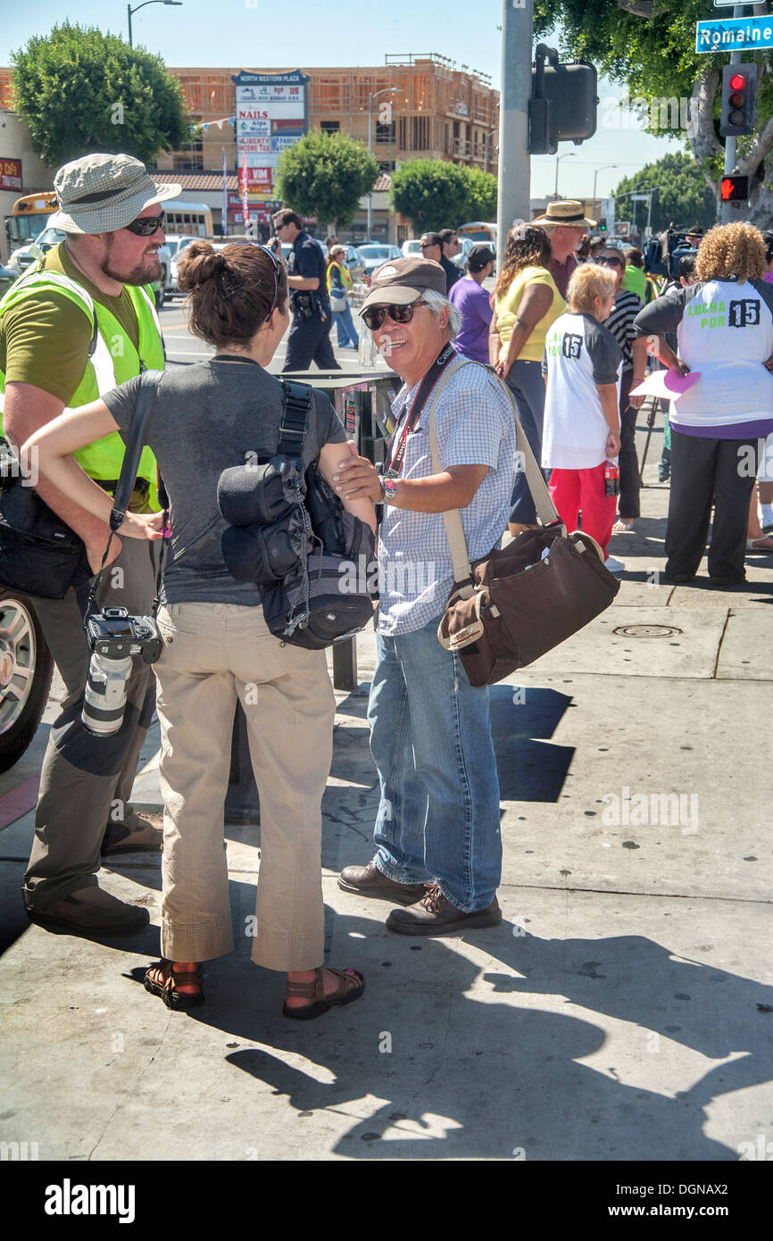 Photojournalists converse while covering a labor demonstration in Los Angeles. Associated Press photographer Nick Ut on right. Stock Photo