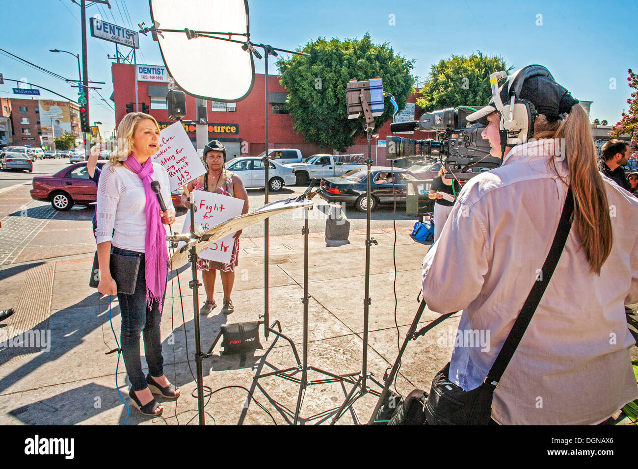 A television broadcast journalist interviews an African American woman participant in a demonstration of fast food workers in LA Stock Photo