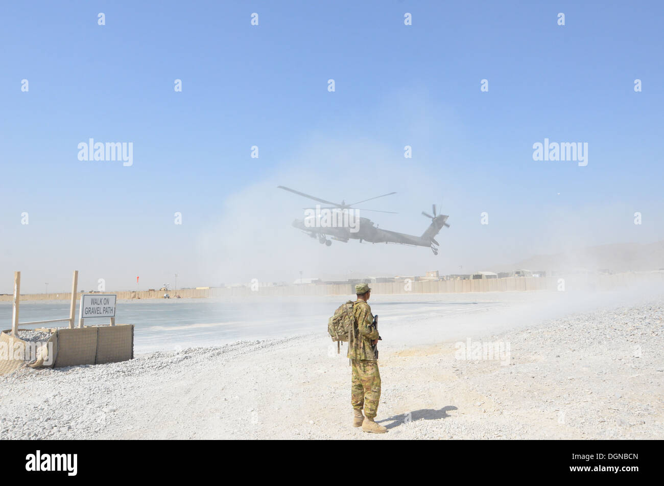 Specialist Daniel Johnson, a petroleum supply specialist with Troop E, Task Force Saber, 1st Combat Aviation Brigade, gets dusted by an AH-64D Apache helicopter practicing landings at Kandahar Airfield, Afghanistan Oct. 13, 2013. Stock Photo
