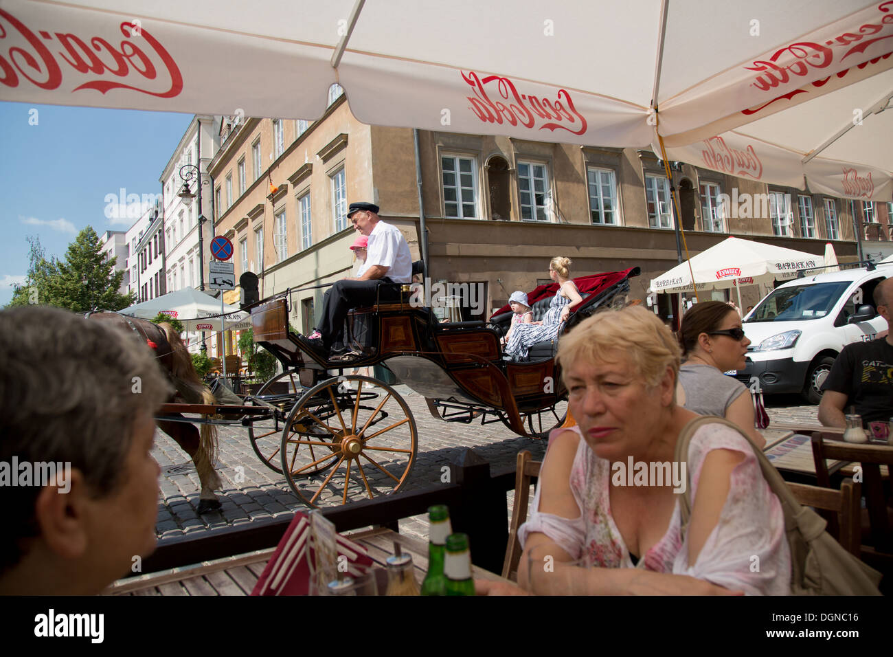 Warsaw, Poland, tourists in a street cafe and a coachman Stock Photo