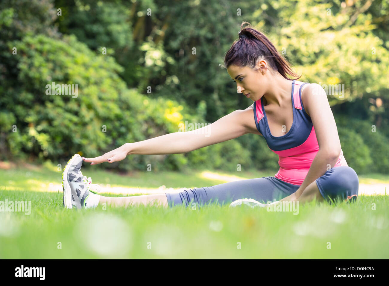 Pretty sporty woman stretching her leg Stock Photo - Alamy