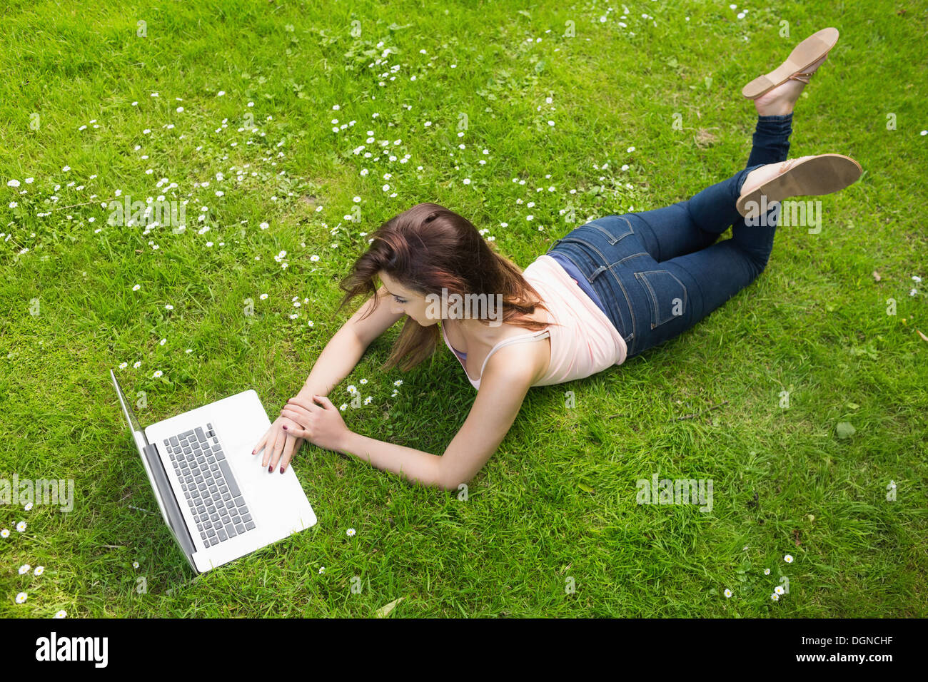 Pretty young woman lying on a lawn using her laptop Stock Photo - Alamy
