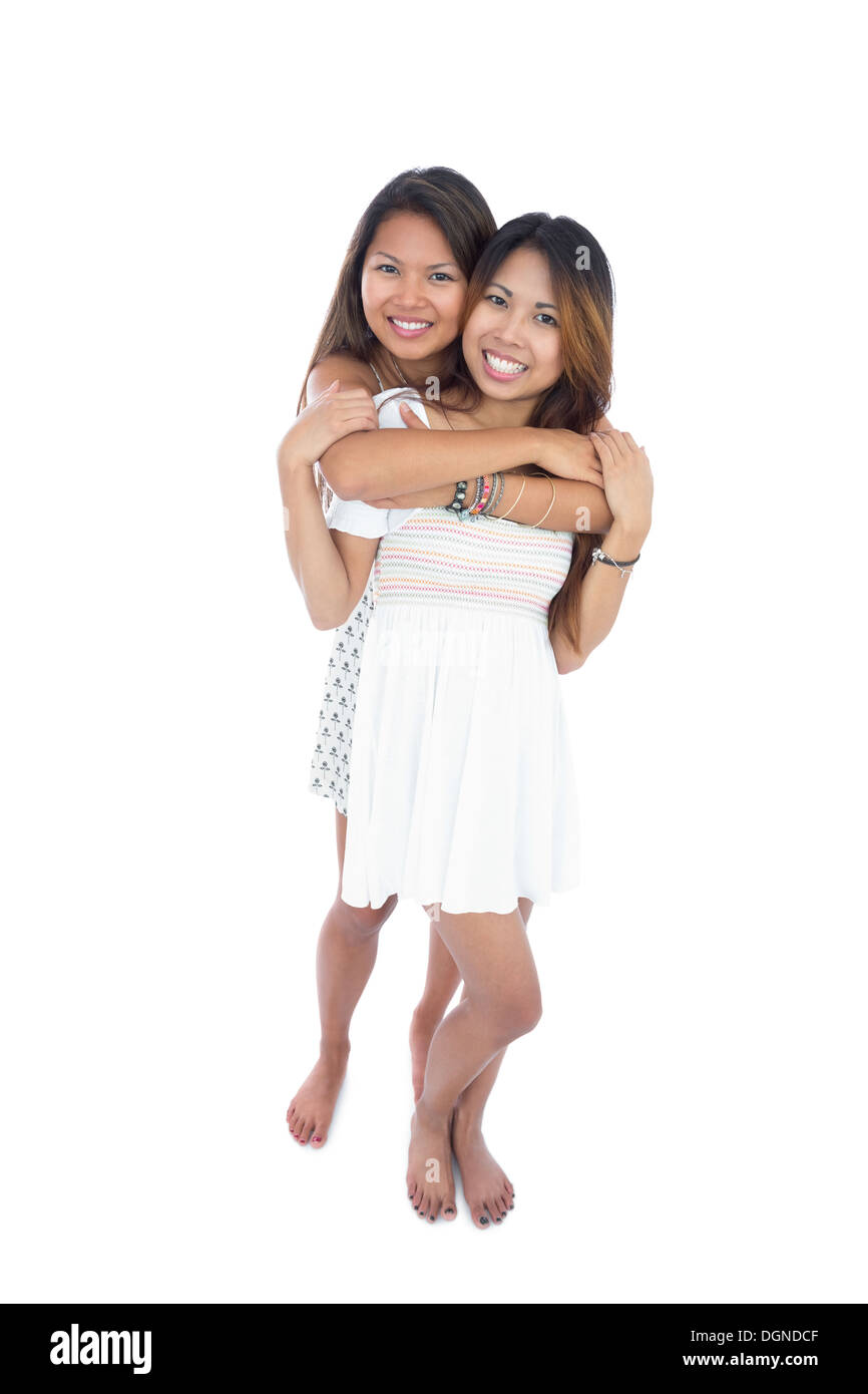 Two pretty sisters hugging in front of the camera Stock Photo