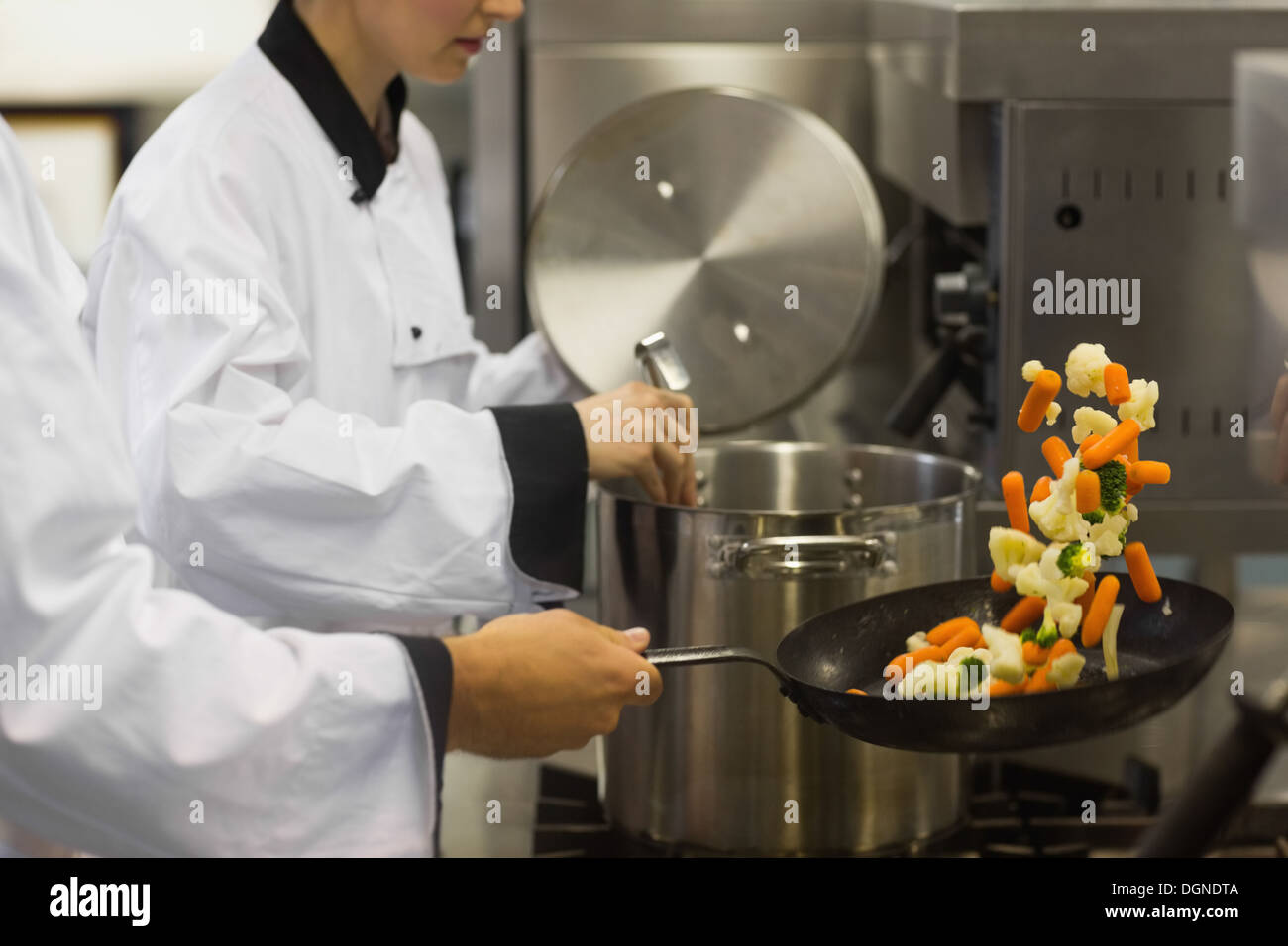 Two chefs working in a busy kitchen Stock Photo