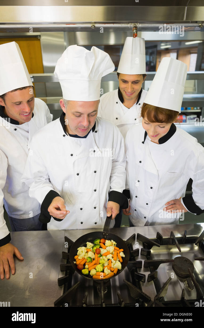Experienced head chef explaining something to his colleagues Stock Photo