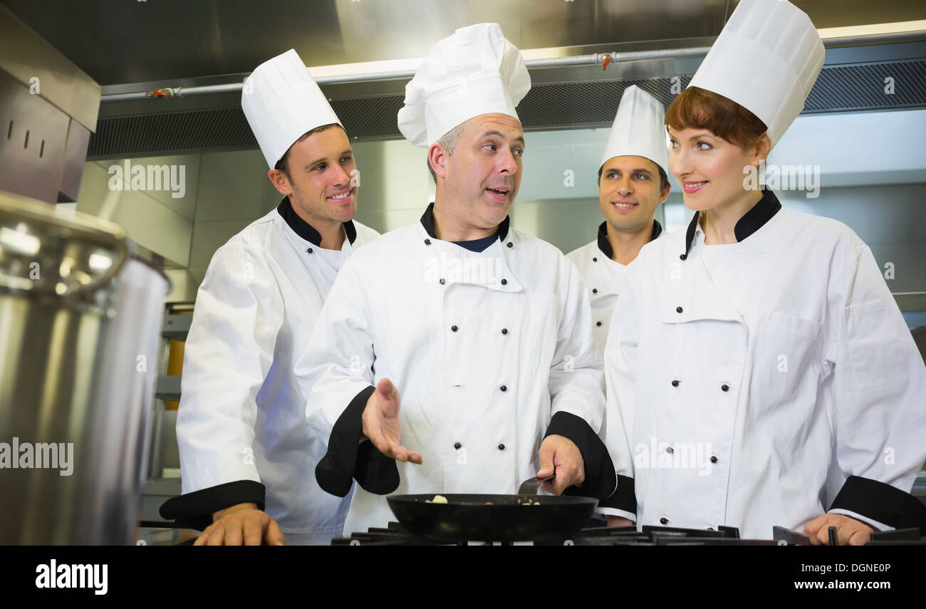 Experienced head chef explaining food to his colleagues Stock Photo