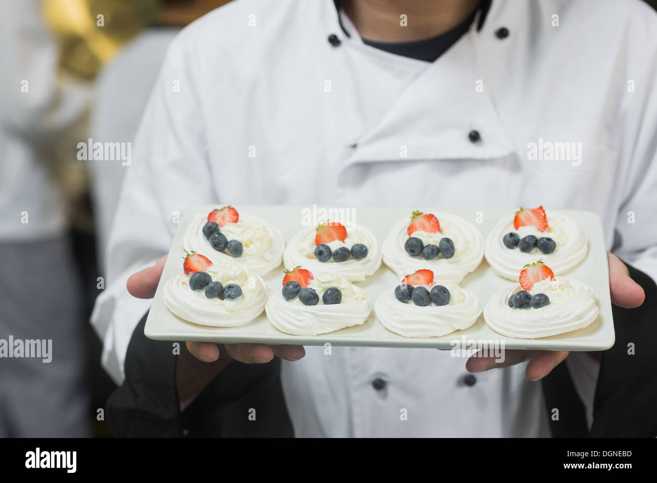 Chef presenting plate of meringues Stock Photo