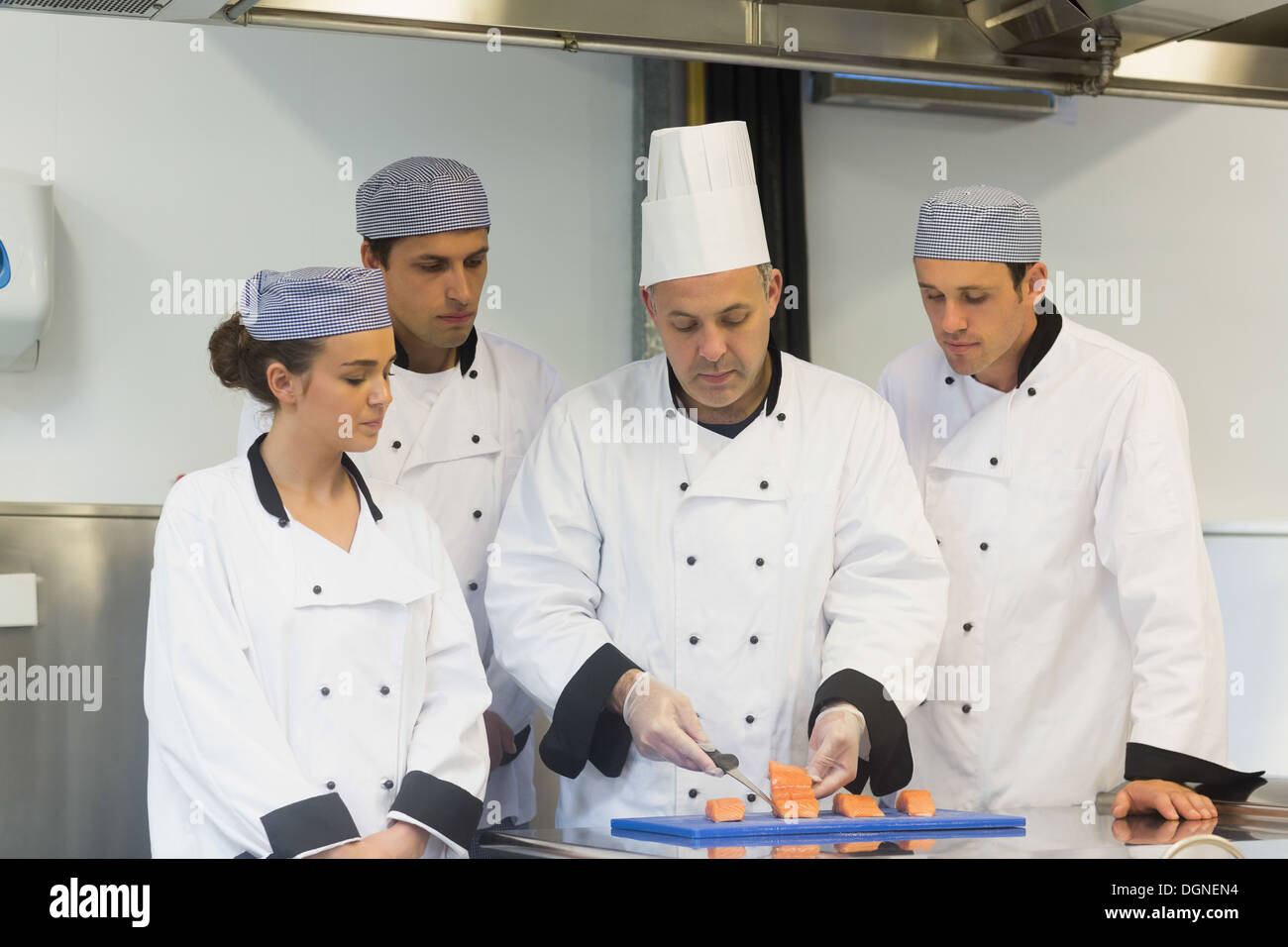 Head chef teaching how to fillet salmon Stock Photo