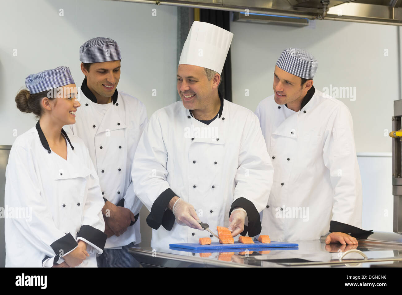 Smiling head chef teaching how to fillet salmon Stock Photo