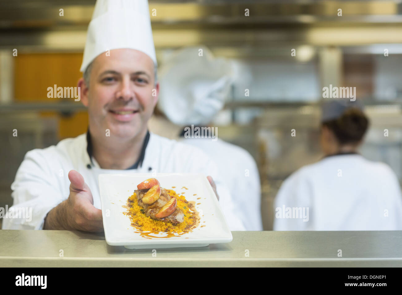 Experienced mature chef presenting a dish Stock Photo
