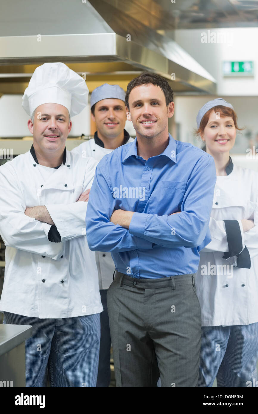 Handsome manager posing with some chefs Stock Photo