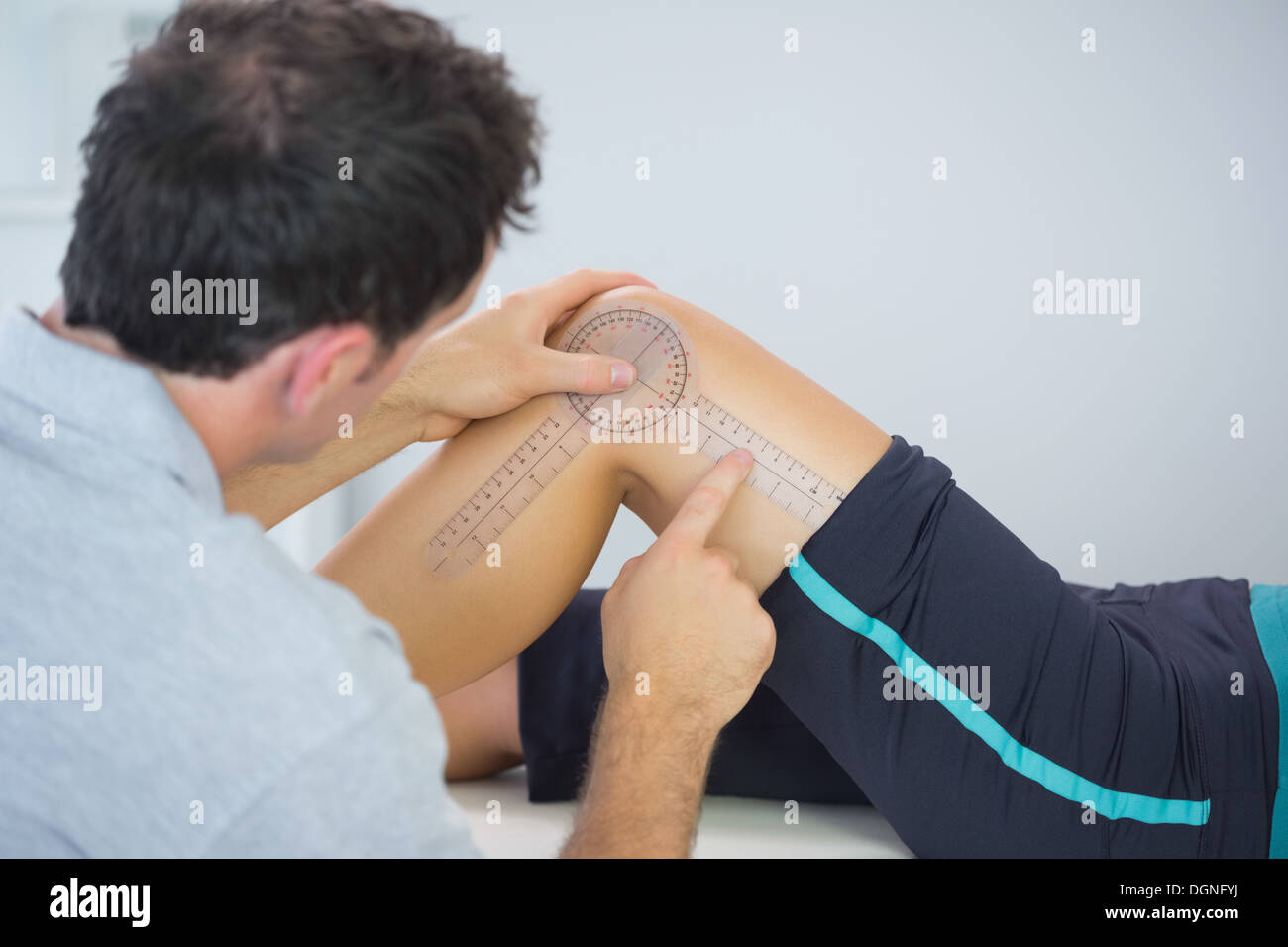 Physiotherapist measuring knee with goniometer Stock Photo