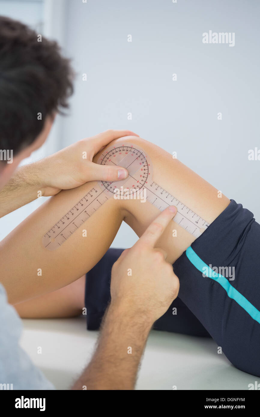 Physiotherapist examining knee with goniometer Stock Photo