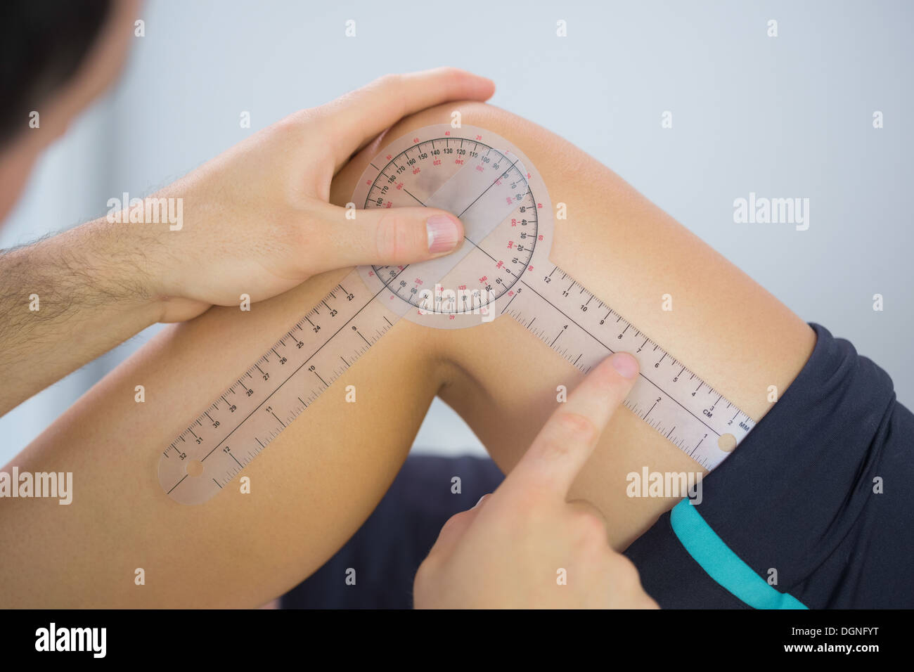 Physiotherapist examining knee angle with goniometer Stock Photo