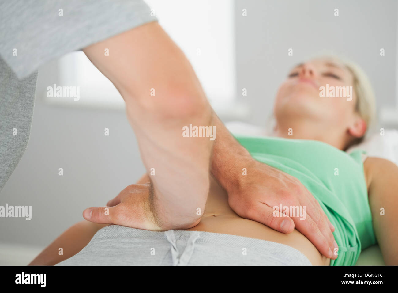 Physiotherapist checking patients pelvis alignment Stock Photo