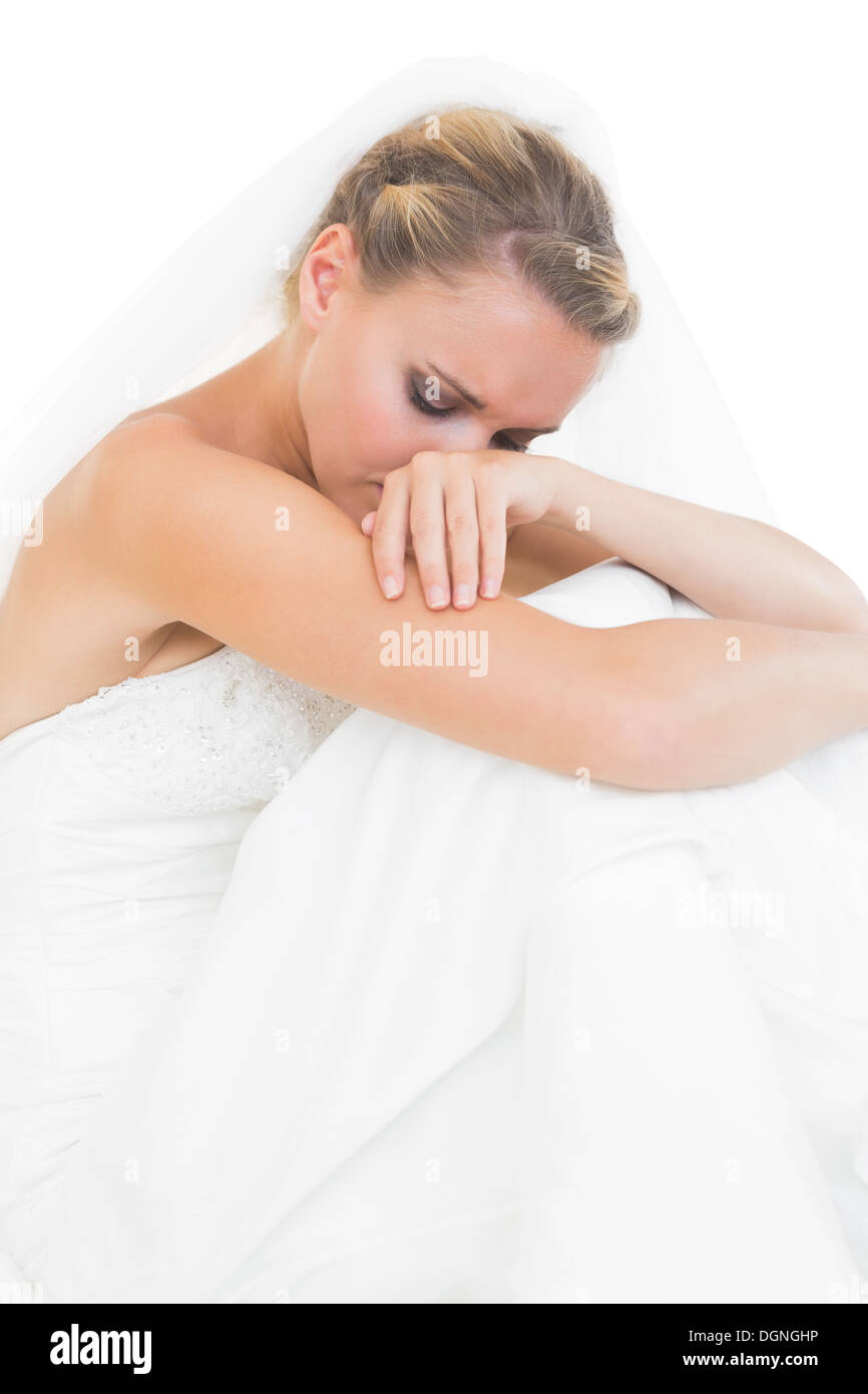 Troubled blonde bride sitting on floor Stock Photo