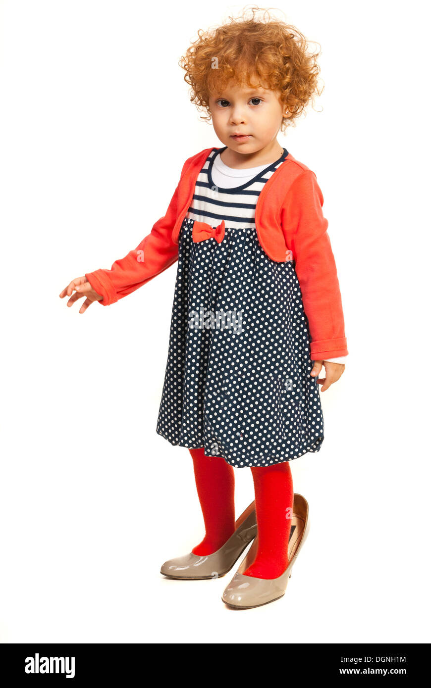 Toddler girl wearing mommys shoes isolated on white background Stock Photo