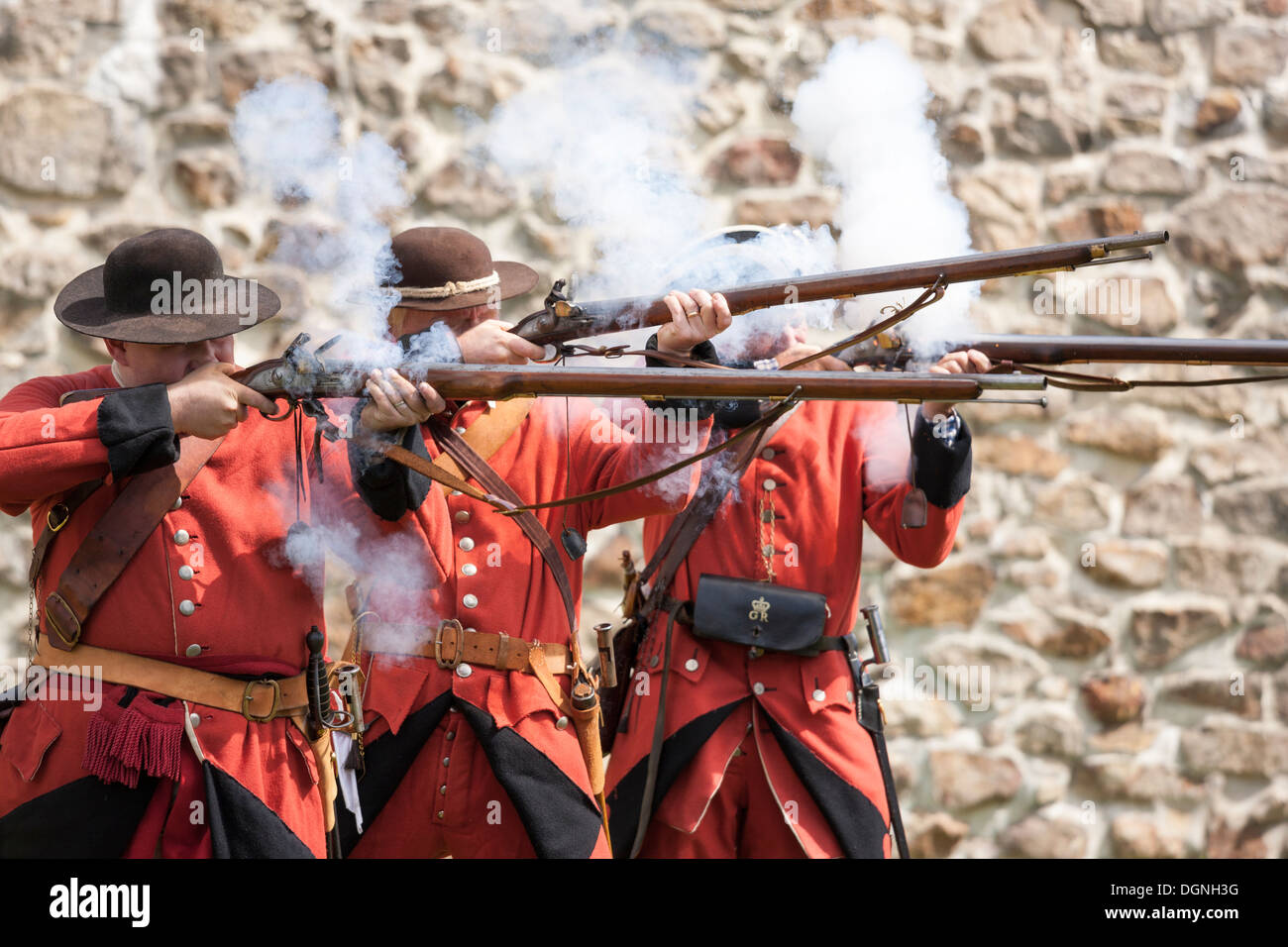 Soldiers firing flintlock muskets in re-enactment French & Indian American Revolution Revolutionary War of Independence Stock Photo