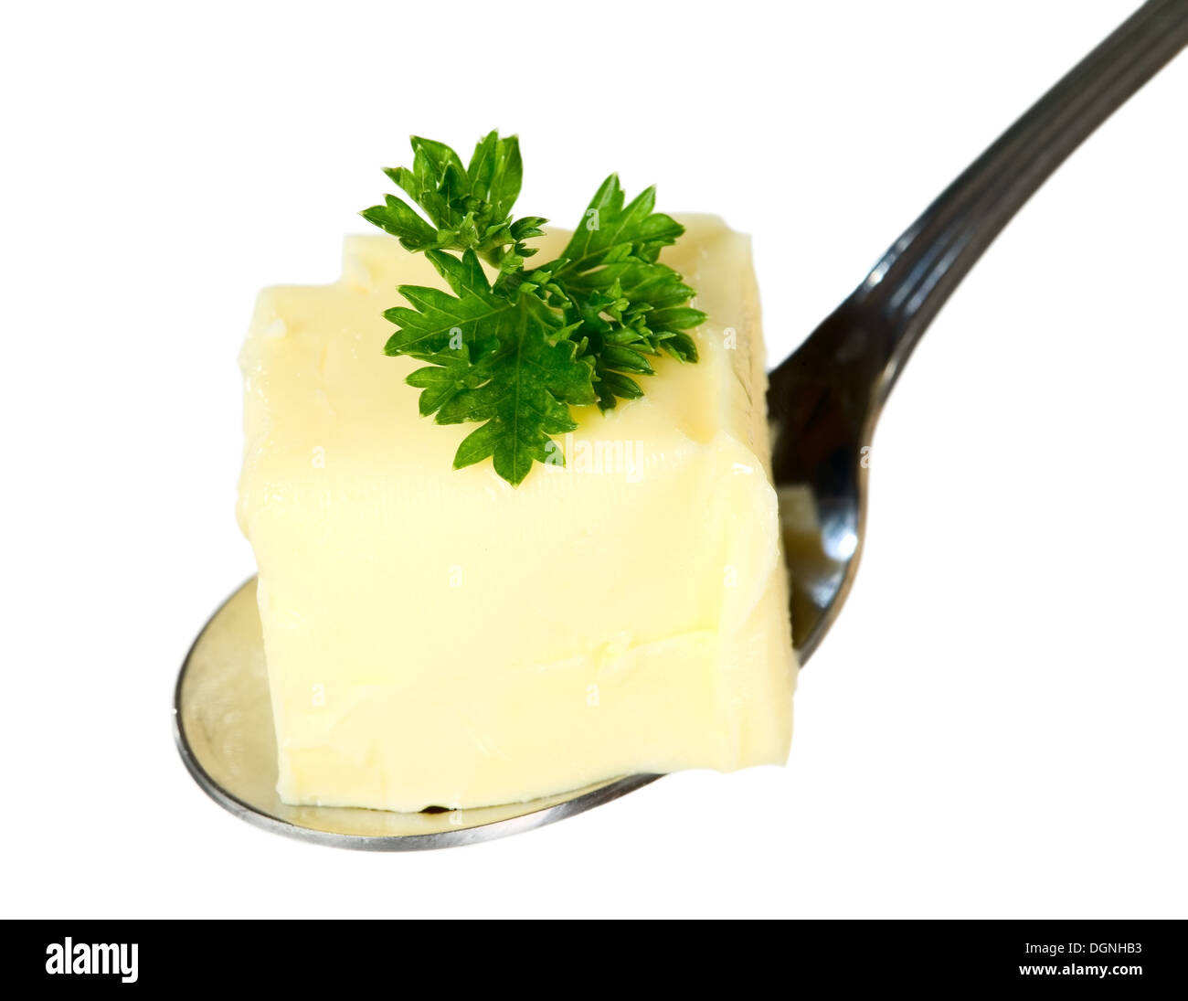 Yellow butter with parsley is being hold with spoon, food concept Stock Photo