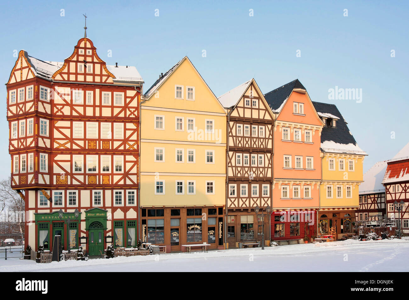 Historic row of houses on the market square in snow in the evening light, winter in Hessenpark, Neu-Anspach, Taunus, Hesse Stock Photo