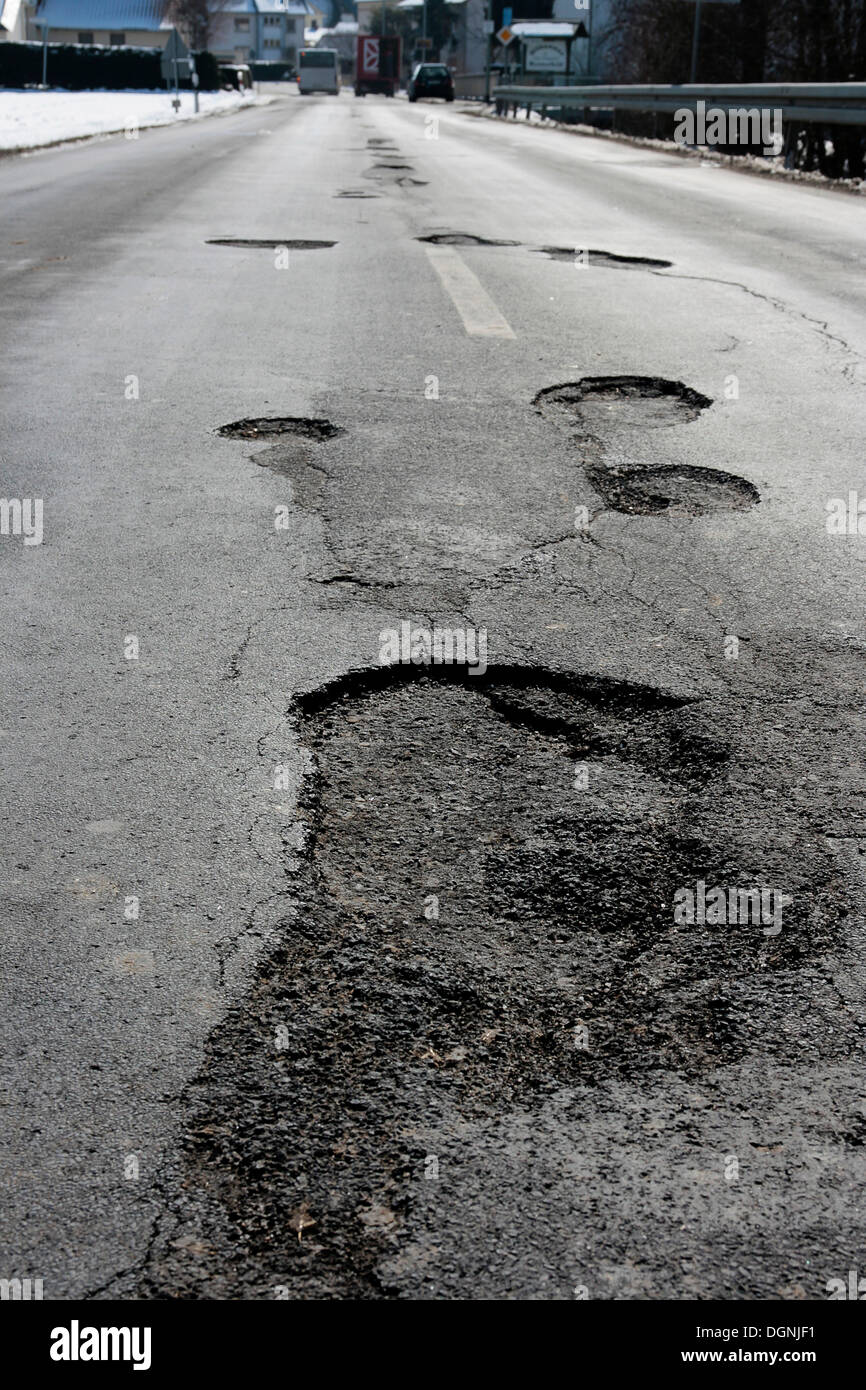 Potholes in an asphalt road caused by frost damage in the cold winter 2009-2010 Stock Photo