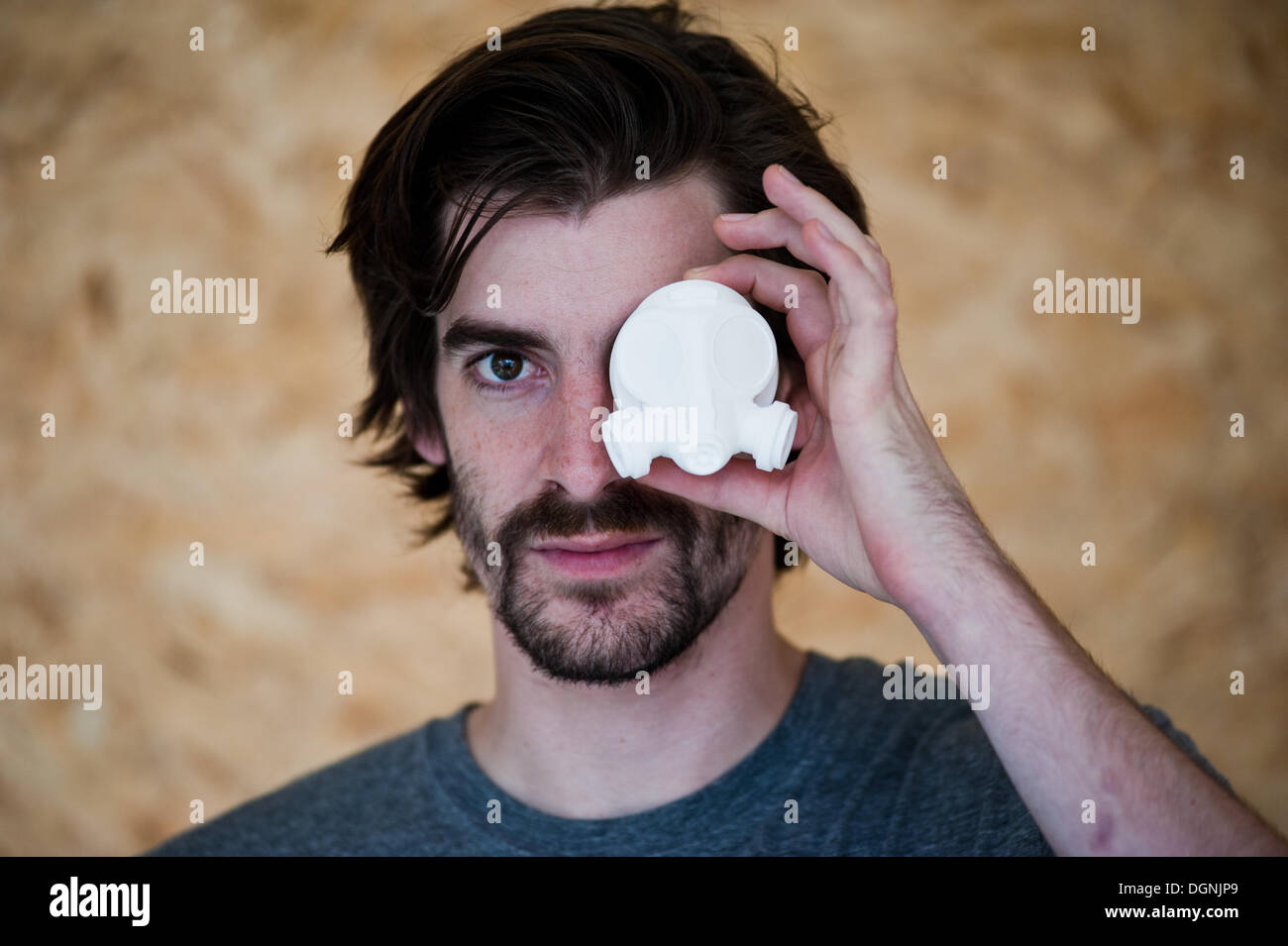 London, UK - 23 October 2013: Nick Allen, founder of 3D Print UK, holds a 3D printed custom center cap for a wheel at the 3D Print UK studio in Bermondsey. Printed using a EOS Formiga P100, Selective Laser Sintering machine and PA2200 Nylon. Stock Photo