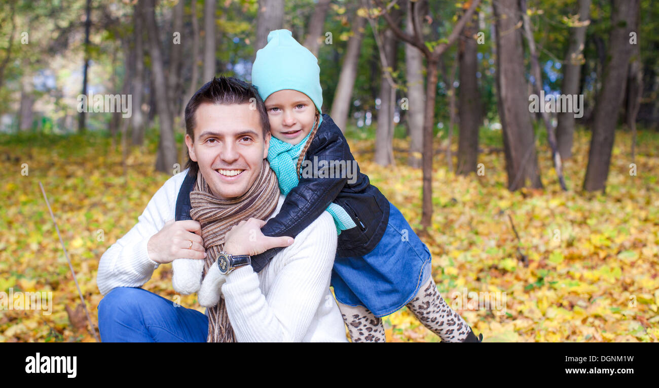 Portrait of Young father walking with his cute daughter in autumn park ...