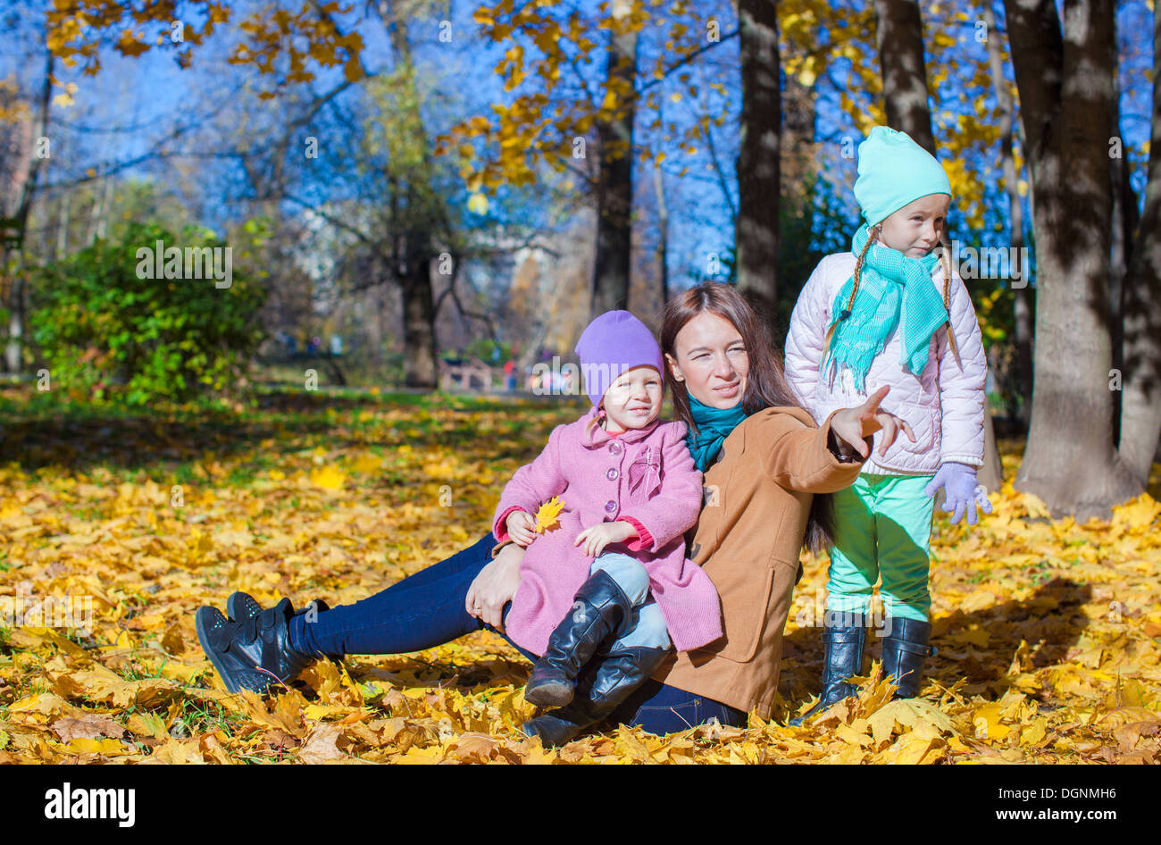 Little girls and young mother in autumn park Stock Photo - Alamy