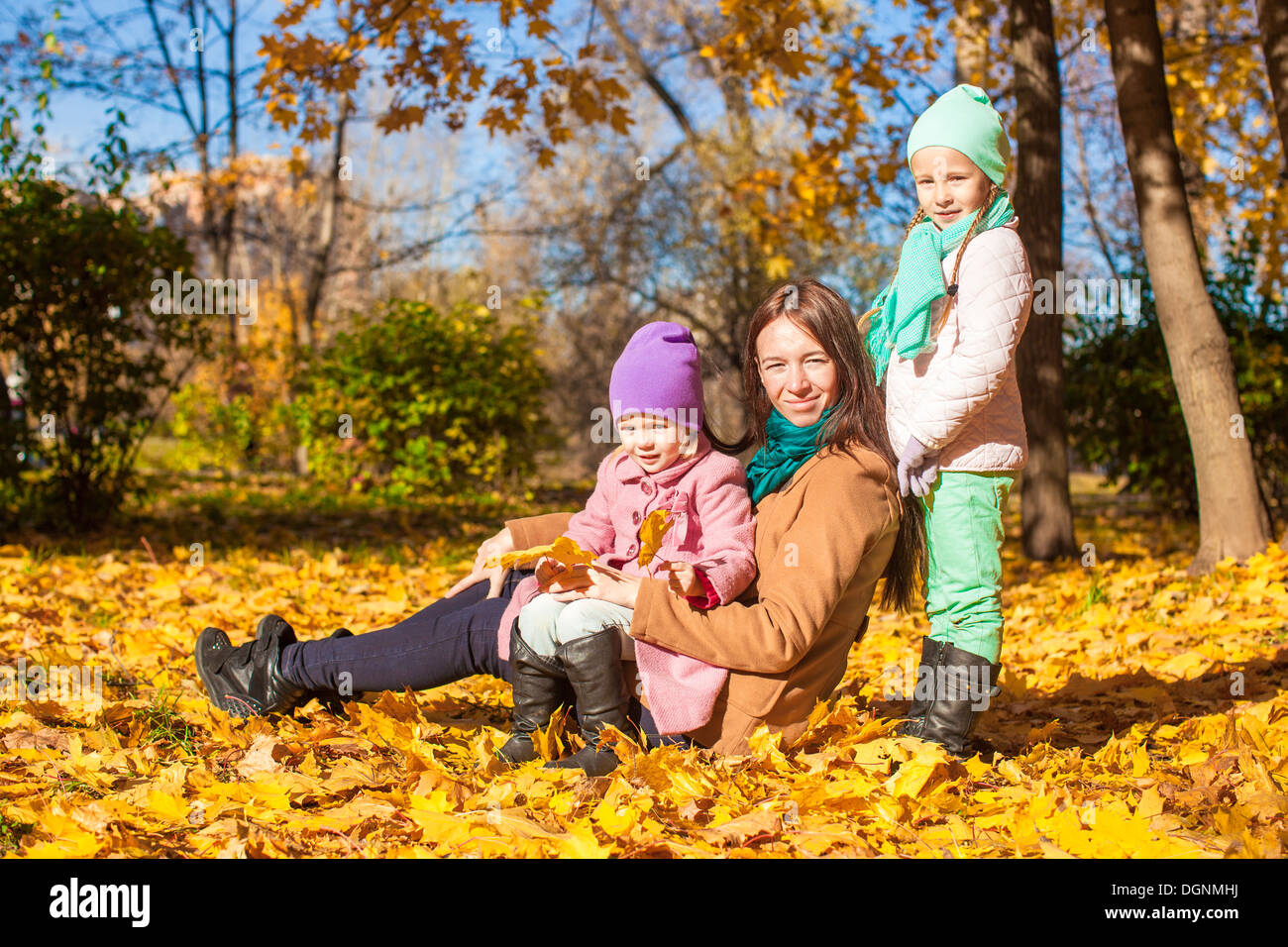 Little girls and young mother in autumn park on sunny warm day Stock ...