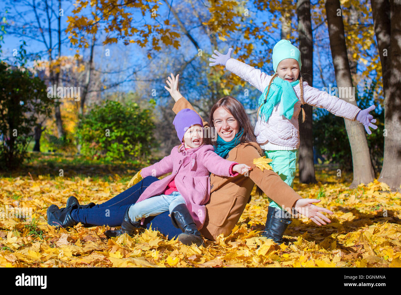 Little girls and young mother in autumn park have fun Stock Photo - Alamy
