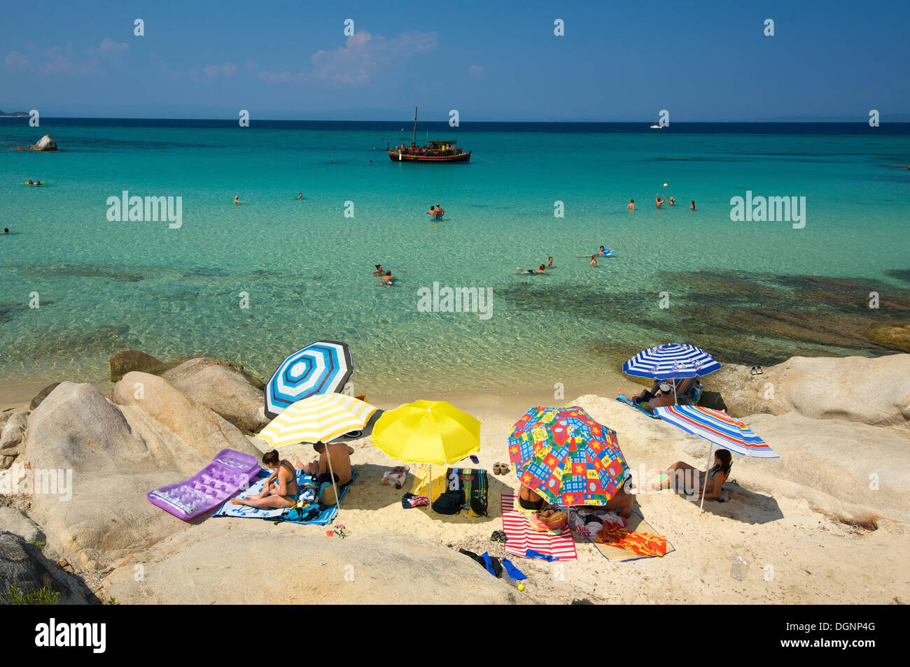 Tourists with parasols at the beach of Portokali, Kavourotypes, Sithonia, Chalkidiki or Halkidiki, Greece, Europe Stock Photo