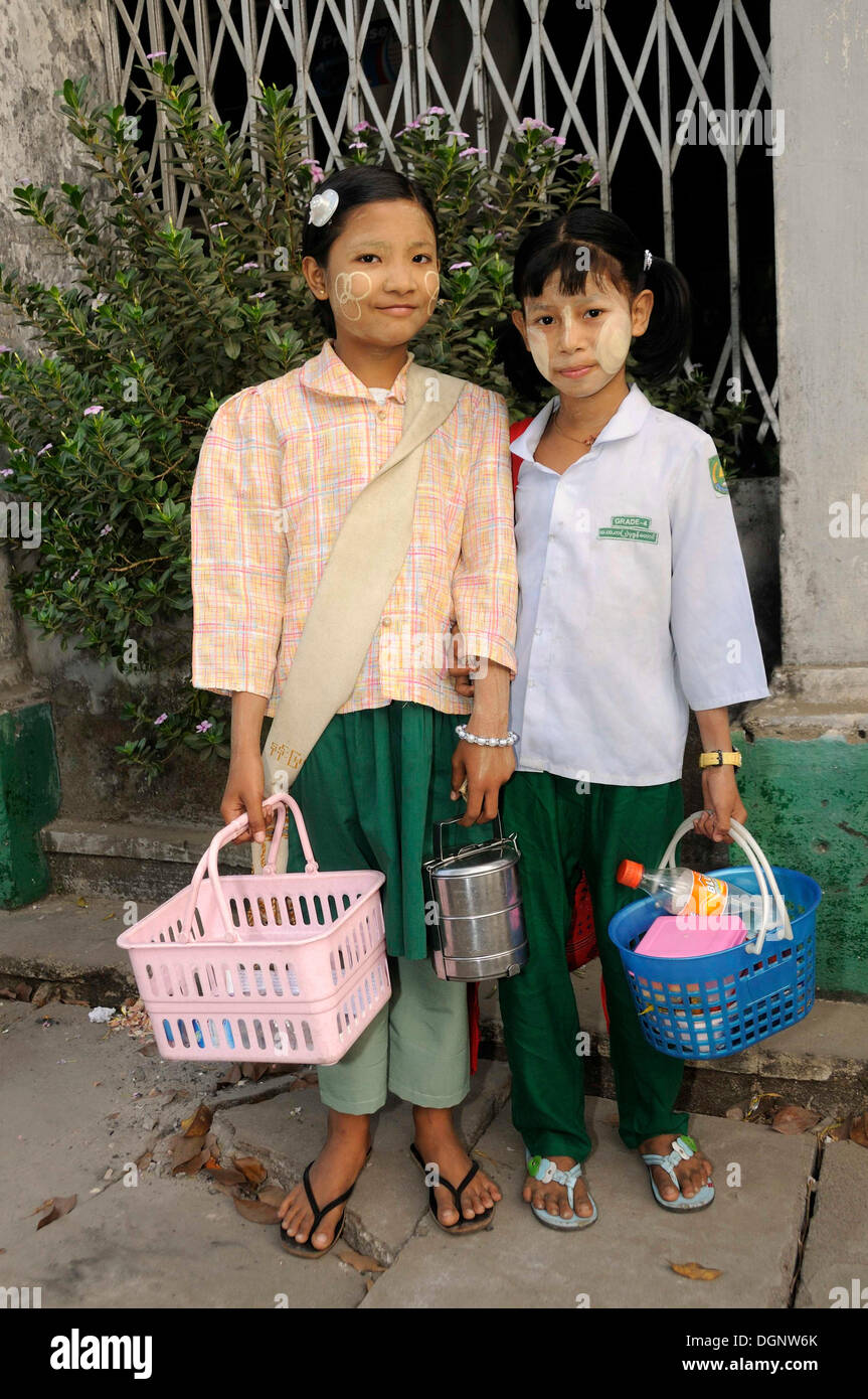 Female pupils with Tanaka paste on their faces wearing school uniforms, historic centre of Yangon, Rangoon, Myanmar, Burma Stock Photo