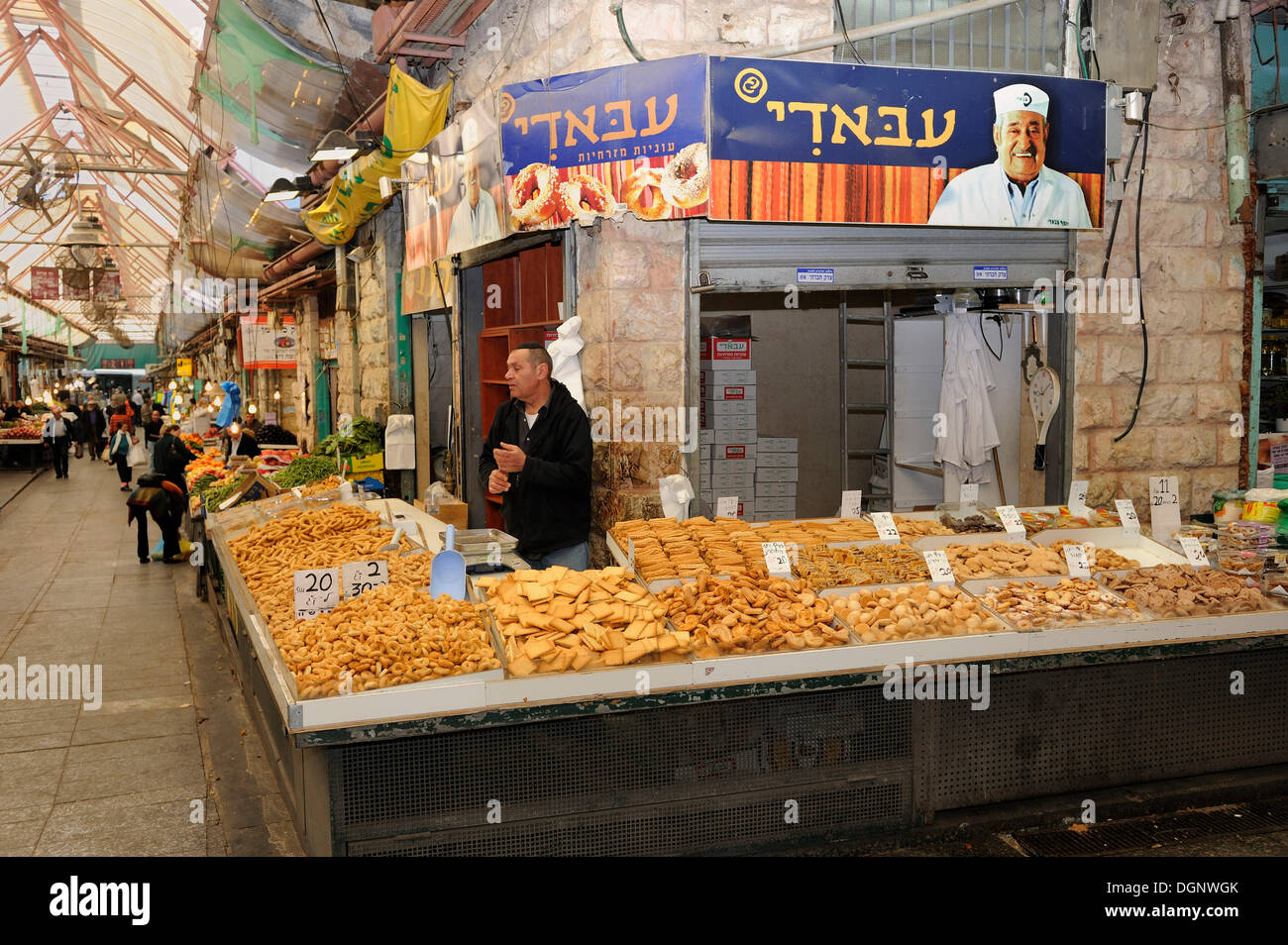 Jewish vendor offering a variety of baked goods for sale on a stall at the Jewish Mahane Yehuda market, Jaffa Road, Jerusalem Stock Photo