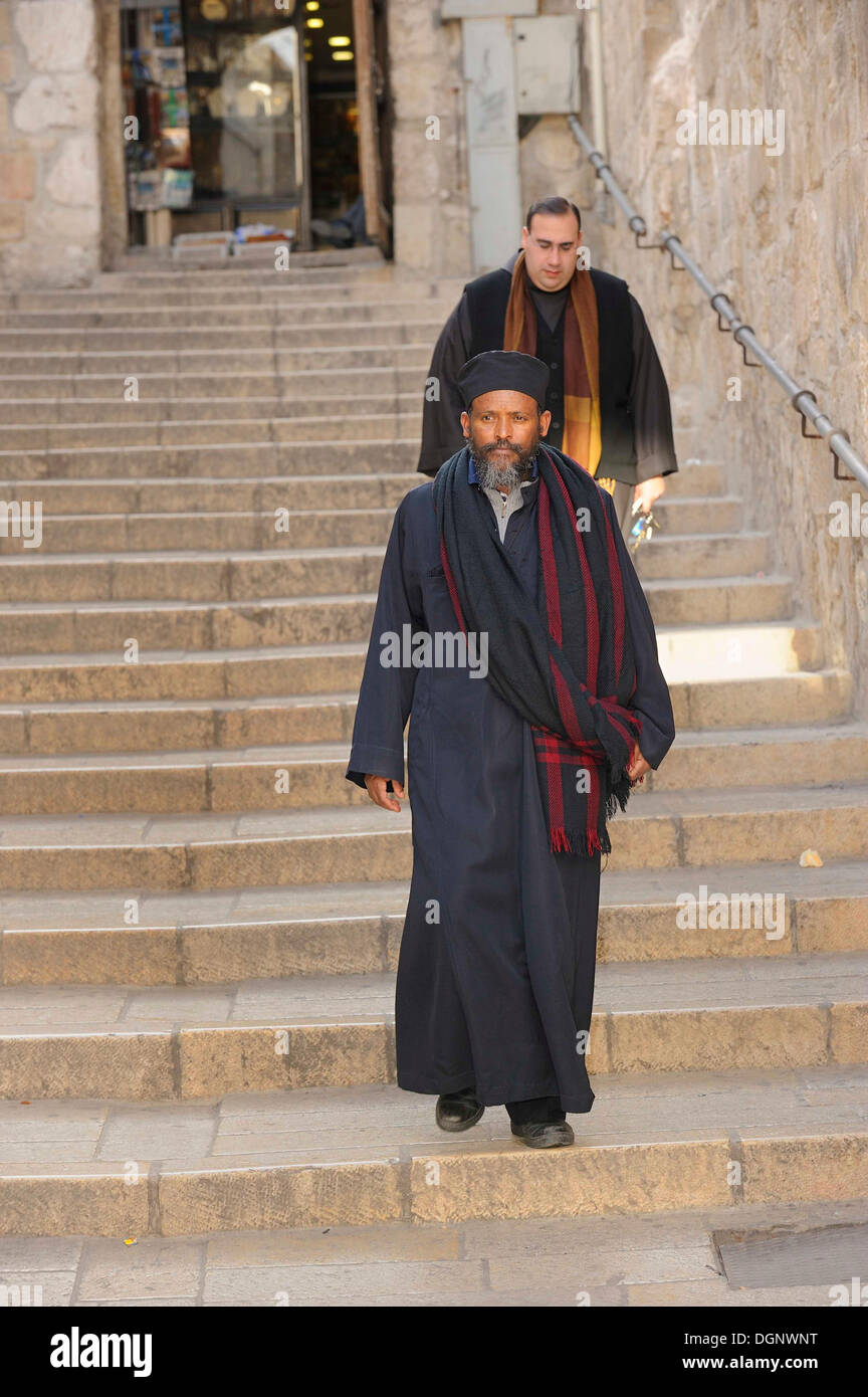 Priests of various denominations, Roman Catholic and Ethiopian Orthodox, walking down stairs towards the Church of the Holy Stock Photo