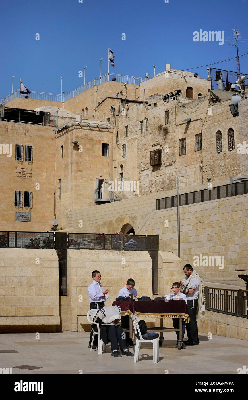 Bar Mitzvah, Jewish coming of age ritual around a prayer table, buildings of the Jewish Quarter at the Wailing Wall or Western Stock Photo