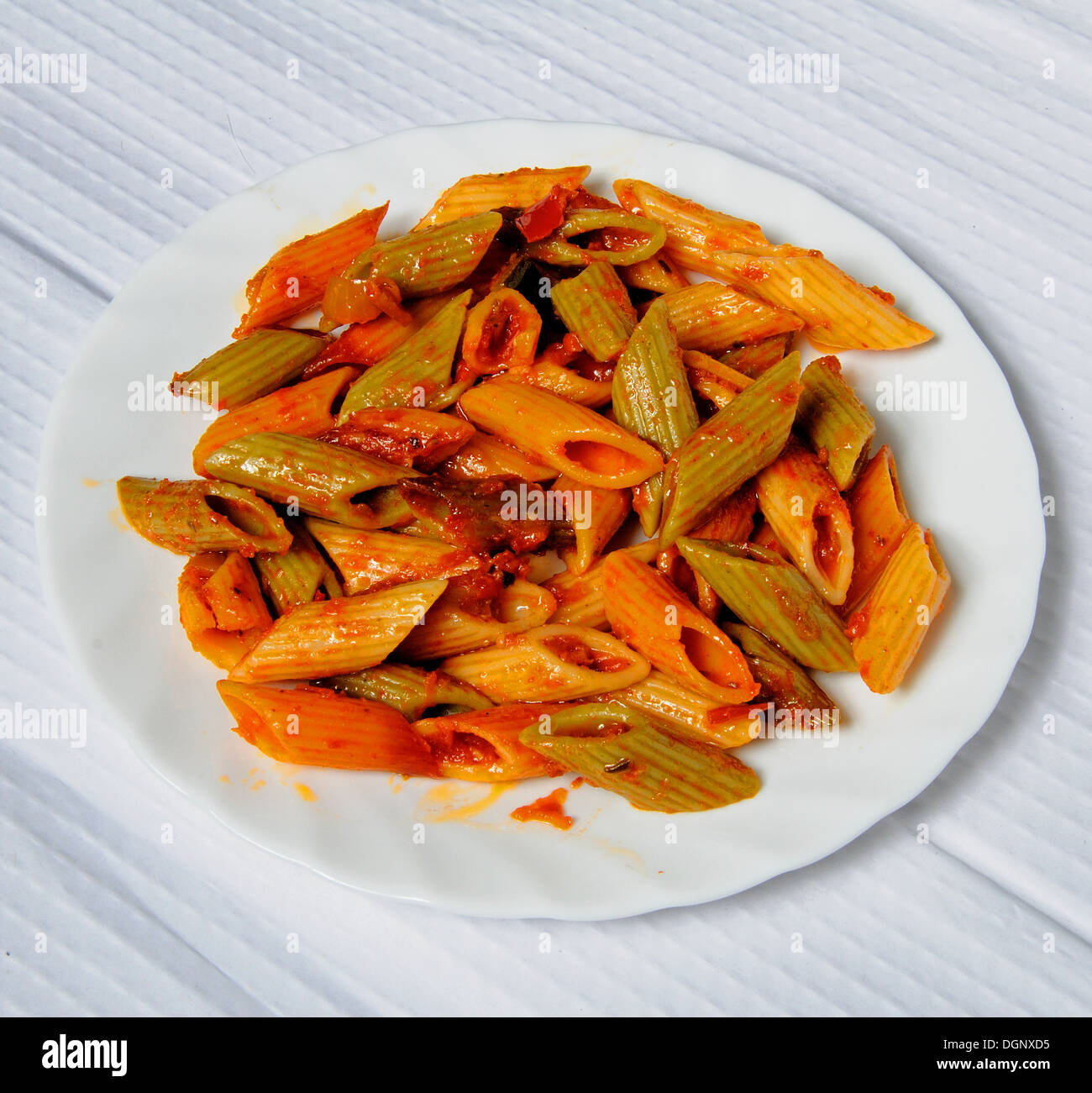 Multicoloured Penne pasta in tomato sauce Stock Photo Alamy