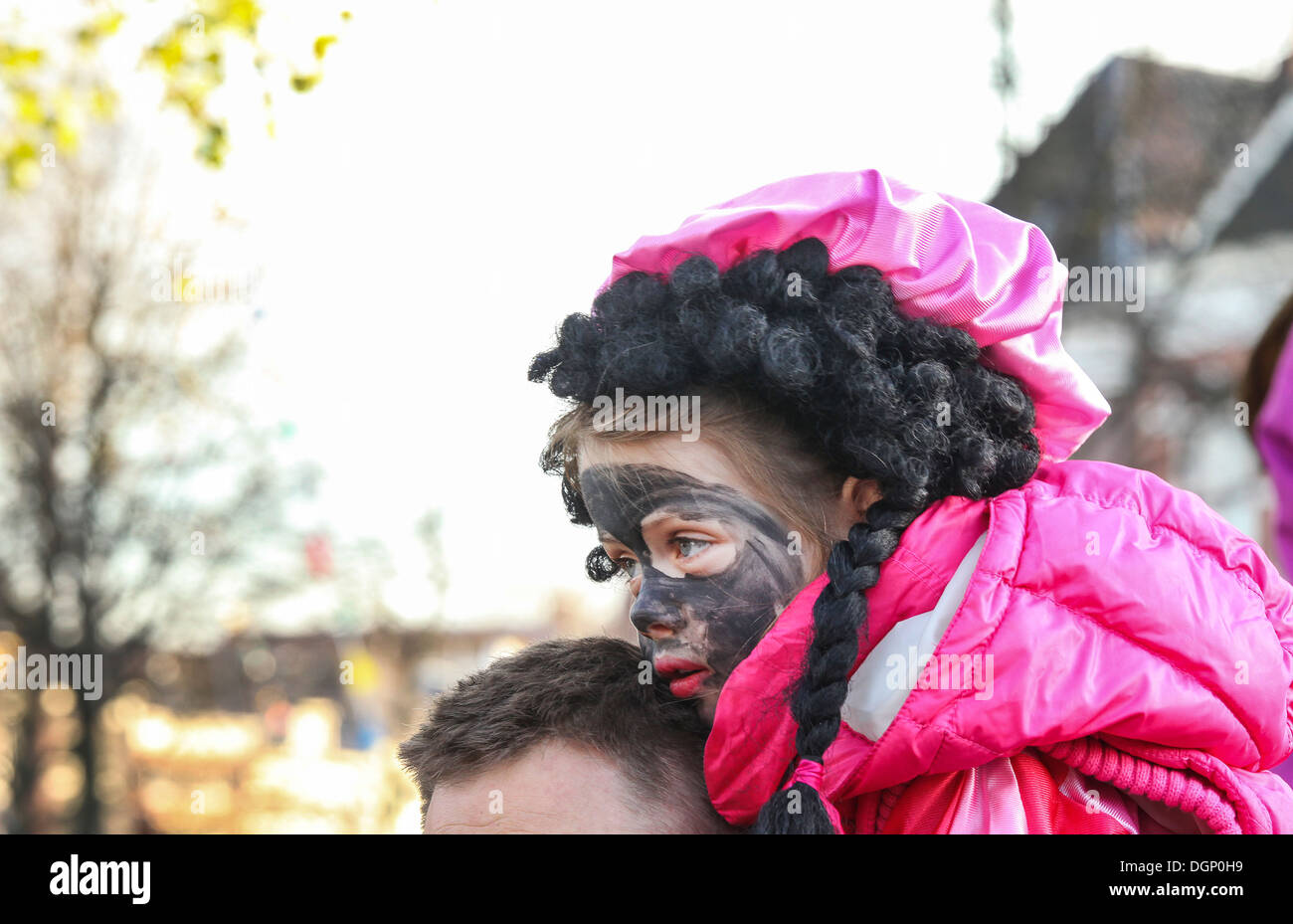 Small Dutch girl with black paint on face on shoulders of daddy as Black Pete Piet at Sinterklaas feast Stock Photo