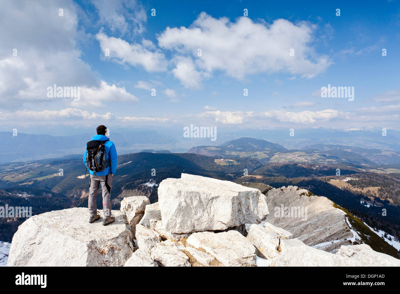 Hiker standing on the summit of Weisshorn mountain above Radein and the Bletterbachschlucht gorge, Ueberetsch and Unterland at Stock Photo