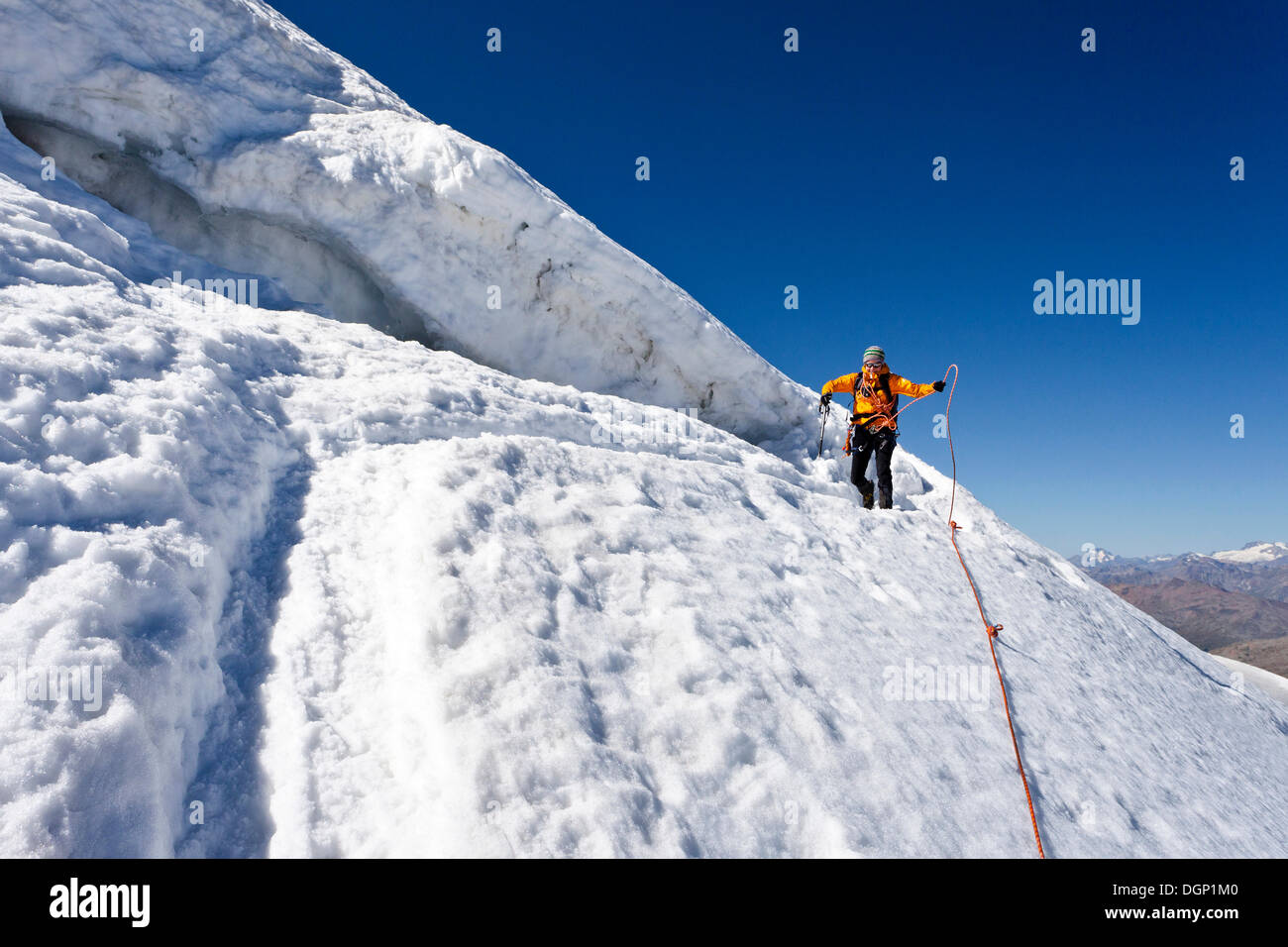 Hiker standing next to a crevasse, descending from Monte Cevedale ...