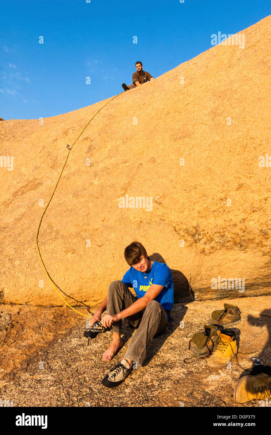 Young man climbing at Bogenfels, Spitzkoppe area, Damaraland, Namibia, Africa Stock Photo