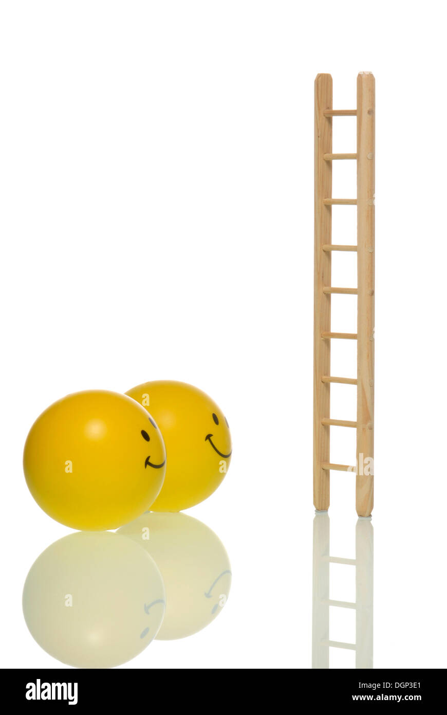 Two smileys in front of a ladder, symbolic image for the ladder of success Stock Photo