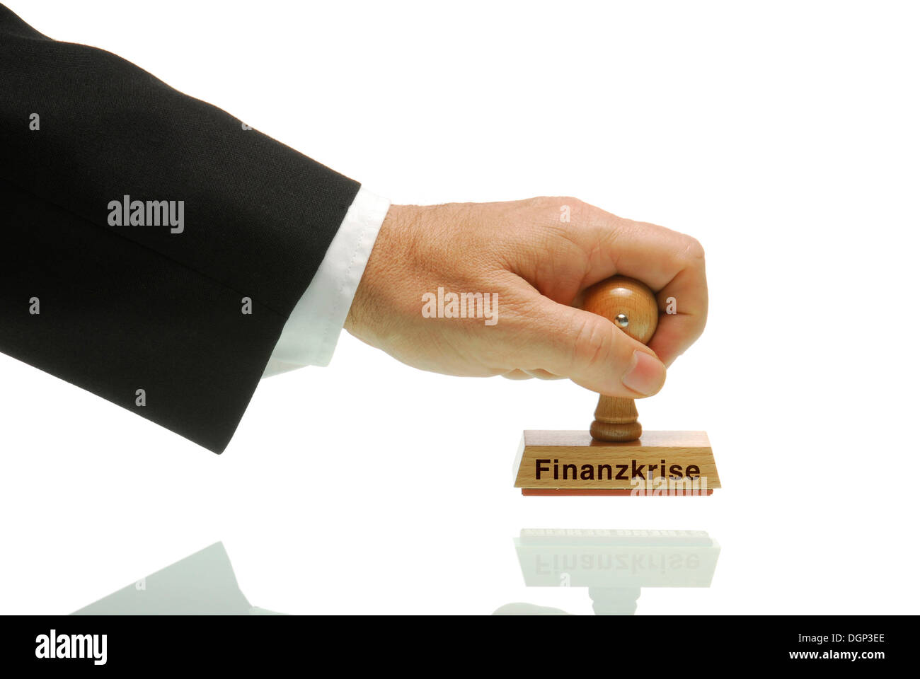 Manager hand holding a stamp labelled Finanzkrise, German for financial crisis Stock Photo